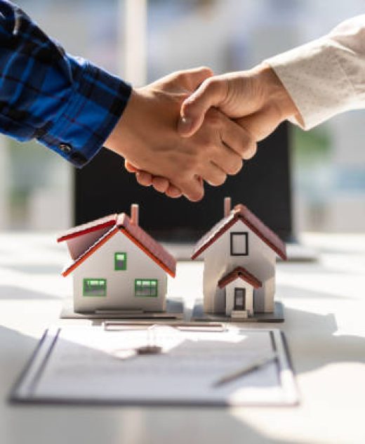Real estate agents shake hands after the signing of the contract agreement is complete.